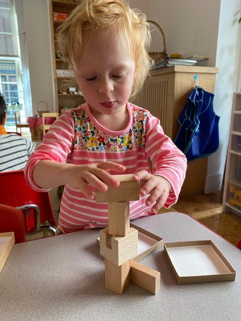 Child stacking wooden blocks